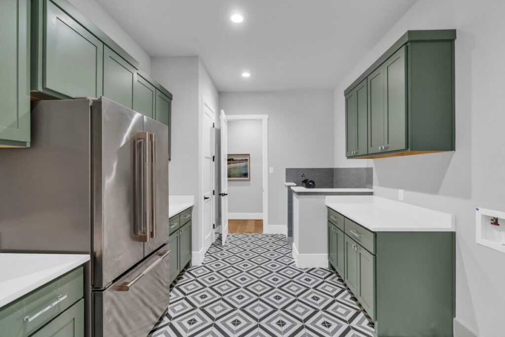 Laundry room with green cabinets